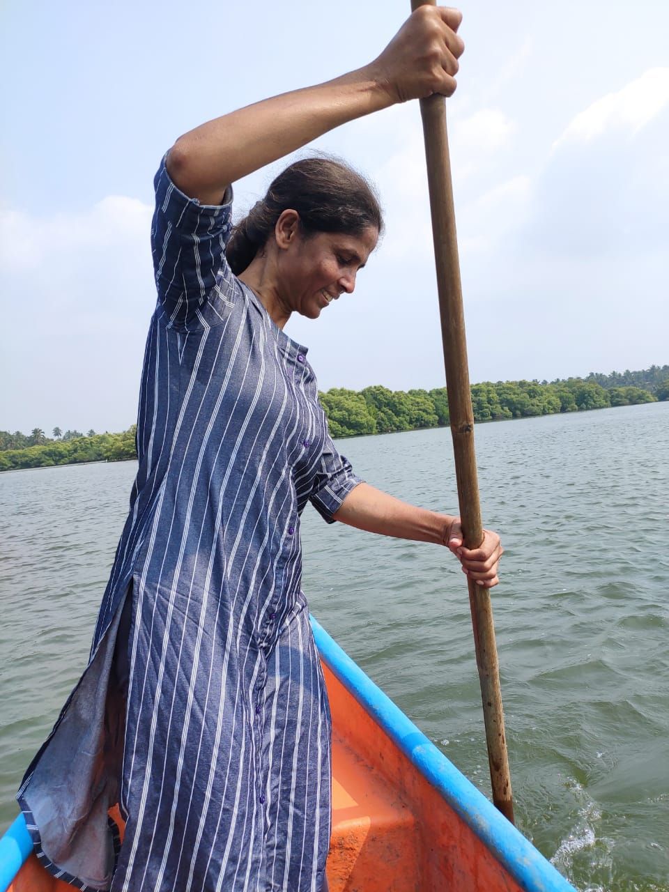 Diana Tavares standing in a canoe, poling across a river